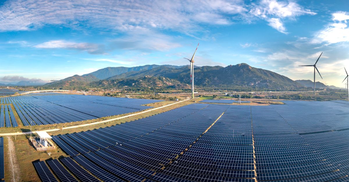 Champ de panneaux solaires sous un ciel bleu, symbolisant l'énergie renouvelable et l'investissement vert.